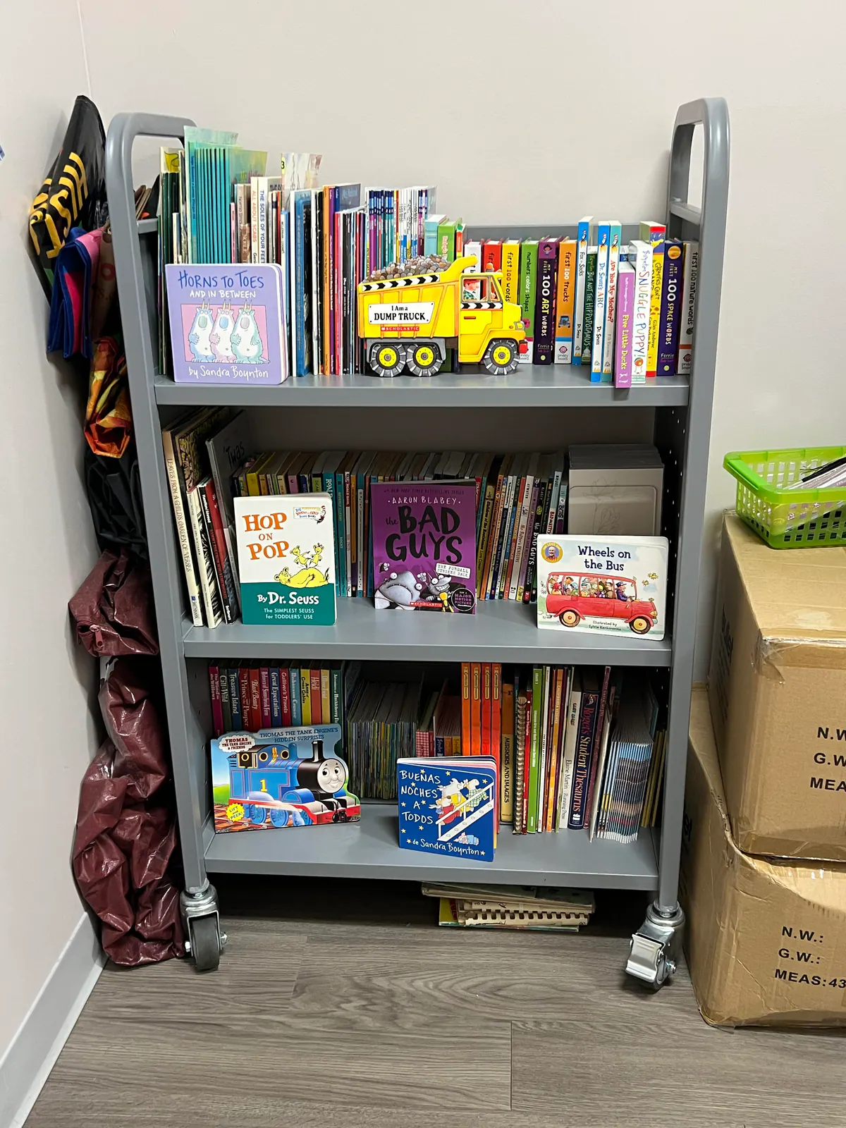 A rolling cart filled with children’s books for the Listen Through Literacy program
